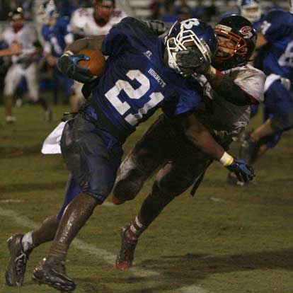 A muddy Chris Rycraw tries to run through the target.