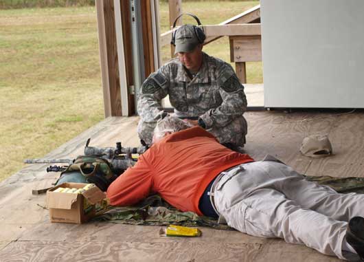 Bryant Police Department Sgt. Shawn Fullington assists CPA participant Dennis Berry with the .308 Sniper rifle. (Photo by Lana Clifton)