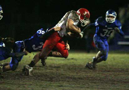 Holden Chavis latches onto Cabot's Spencer Smith (3) as Cody Perlson (38) closes in to help. (Photo by Rick Nation)