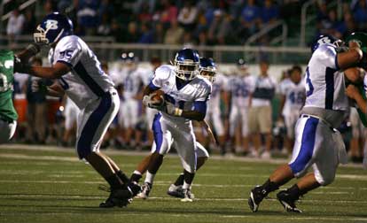 Chris Rycraw heads through a hole provided by Austin Johnson (75) and Justin Rauch (73). (Photo by Rick Nation)