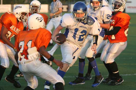 Bryant White quarterback Wesley Akers (12) battles for yardage as the Ridge Road defense converges. (Photo by Rick Nation)