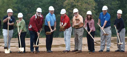 Derek Phillips, Rae Ann Fields, Rick Meyer, Larry Mitchell, Robby Young , Danny Steele, Sandy Miller, Jeremy Lemons, Doug Harvey fling dirt into the air as they break ground at the location for the aquatic center at Bishop Park on Boone Road. (Photo by Lana Clifton)