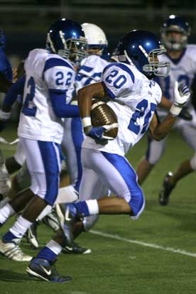 Jalen Bell (20) races upfield escorted by Marcus Wilson (22) and others. (Photo by Rick Nation)