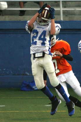 Austin Miller (24) hauls in a pass in front of a Ridge Road defender. (Photo by Rick Nation)