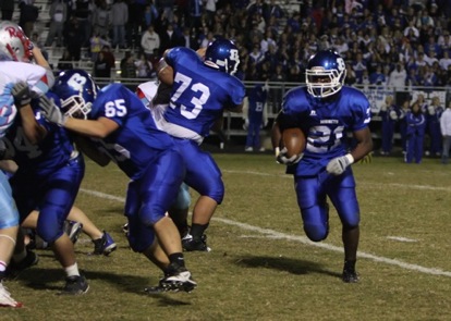 Chris Rycraw (21) cuts off blocks by teammates Justin Rauch (73) and Brett Clemons (65) during Friday's State playoff game. (Photo by Rick Nation)