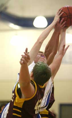 Bryant's Scott Workman goes up between a pair of Lake Hamilton players for a rebound during Monday's game. (Photo by Rick Nation)
