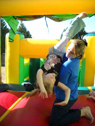 Makayla Shipe does a back flip, with a little help from mom, Sandy, in the Bounce House at the Bryant Animal Shelter Open House.