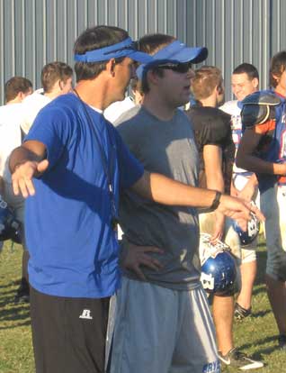 Secondary coach John Wells, left, talks with volunteer assistant Travis Queck during a recent practice. 