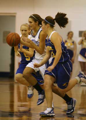 Bryant's Hannah Goshien works the ball up the floor between Sheridan defenders Brittnee Wreyford (5) and Lauren Sweeten. (Photo by Rick Nation)