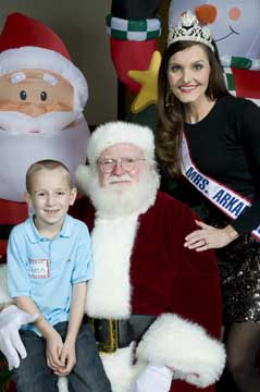 Jaxon Lee, of Benton, took a meeting with the Big Guy and Mrs. Arkansas Nicole Knapp at the CARTI Kids Christmas Party in Little Rock.  (Photo:  Kelly Quinn Photography.)