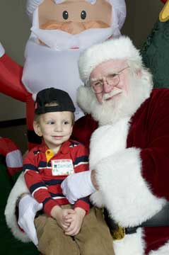 Damian Matte, of Mabelvale, was one of 70 current or former CARTI pediatric cancer patients who participated in the annual CARTI Kids Christmas Party.  Matte made merry at the party with Santa and his elf-for-a-day, Mrs. Arkansas 2009 Nicole Knapp of Conway.  (Photo:  Kelly Quinn Photography.)