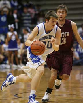 Bryant's L.J. McLaughlin (30) drives past Benton's Nick Garner. (Photo by Rick Nation)