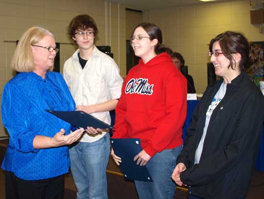 Bryant School Board President Rhonda Sanders presents AP Scholar with Honors Awards to William Chandler, a senior; Kara Cravens, a 2009 graduate; and Jennifer Moulton, a senior.  The award recognizes those students with an average grade of at least 3.25 on all AP Exams taken and of 3 or higher on four or more of the exams. (Photo by Lana Clifton)