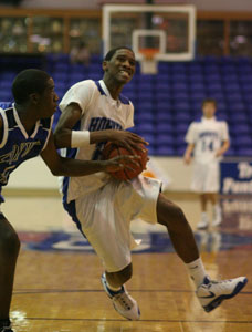 Jonathan Parks goes in for a layup over Benton's Nate Smith and in front of Bryant teammate Cody McPherson.