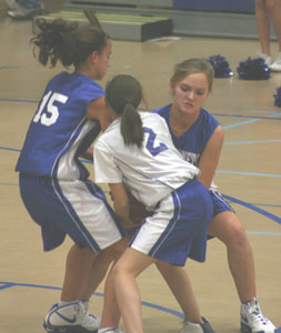 Shelby Gartrell (15) and McKenzie Rice, right, battle Bethel's Lisa Walker for possession.