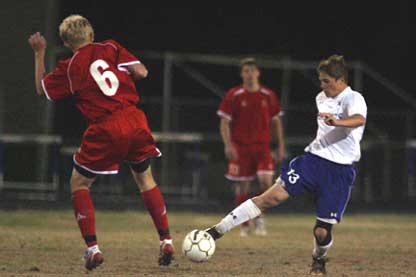 Forrest Fowler (13) tries to get the ball past a Cabot defender. (Photo by Rick Nation)