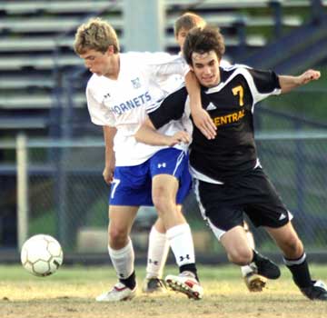 Reed Evans, left, fights a Central player for possession during Tuesday's match. (Photo by Misty Platt)