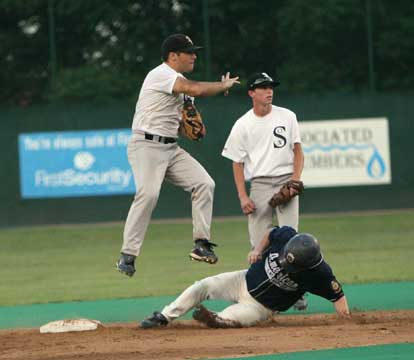 Kaleb Jobe leaps over Little Rock Blue's Tyler Brown as he throw to first in front of teammate Hunter Alford during the third inning of Thursday's 18-1 Bryant Black Sox win. (Photo by Rick Nation)