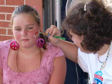 Sara Scroggins gets her face painted by Kate Coffman. (Photo by Lana Clifton)