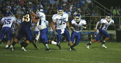 Chris Rycraw, 21, cuts upfield with teammate Austin Johnson (75) and Kaleb Burns (51) clearing the way. (Photo by Rick Nation)