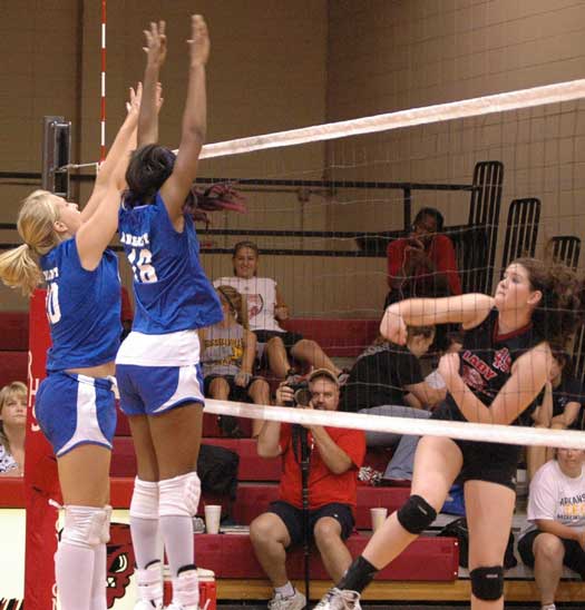 Bryant's Amber Cope and Brianna White leap up to try to block a hit by a Russellville player. (Photo by Mark Hart)
