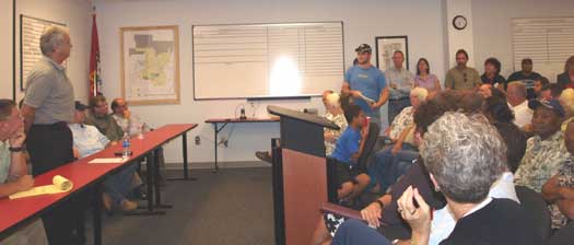 Mayor Larry Mitchell, standing at left, and other area officials listen to one of the citizens gathered at the public forum on Monday night. (Photo by Lana Clifton)