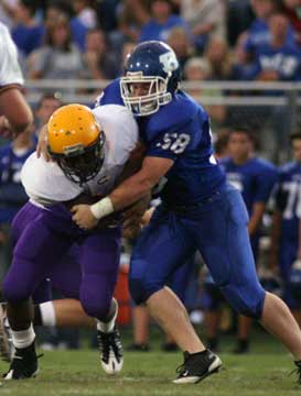 Bryant's Dustin Grimmett (58) brings down Catholic Quieta Thomas. (Photo by Rick Nation)