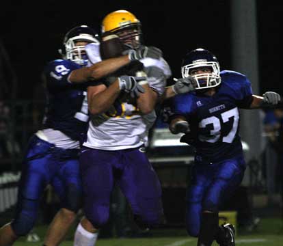 Stanley Oxner (19) knocks the ball from the grasp of Little Rock Catholic receiver Garrett Uekman as Trey Sowell (37) hurries to help out. (Photo by Rick Nation)