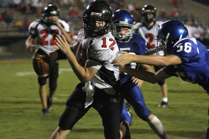 Hayden Stewart (56) gets a hand on Searcy quarterback Reed Haggard (12). Stewart brought him down for a safety late in Thursday's game. (Photo by Rick Nation)