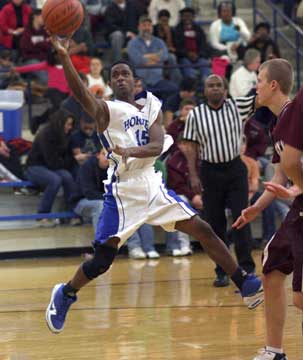 Aaron Bell twists to scoop up a shot after driving around Benton's Zach Stuckey. (Photo by Rick Nation)