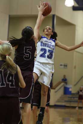 McKenzie Adams (23) puts up a running jumper over Benton's Madi Brooks. (Photo by Rick Nation)