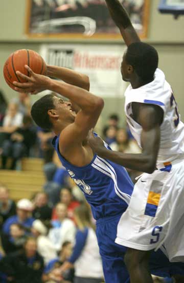 Bryant's Dontay Renuard, left, tries to shoot over or through Sheridan's R.J. Comic. Renuard led all scorers with 21 points in the game. (Photo by Rick Nation)