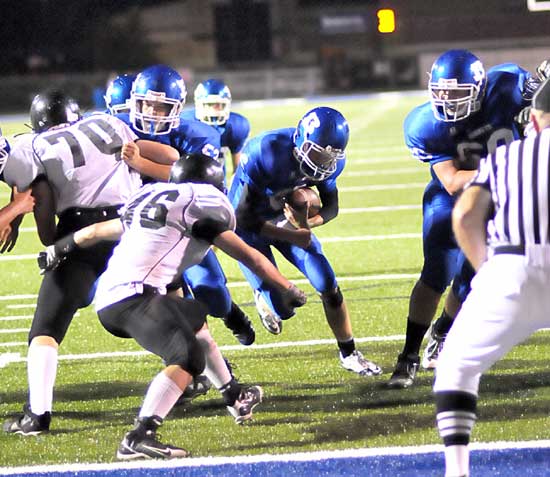 Quarterback Austin Powell ducks his shoulders and heads into the end zone between blocks by Sawyer Ivy (53) and Blake Hobby (60). (Photo by Kevin Nagle)