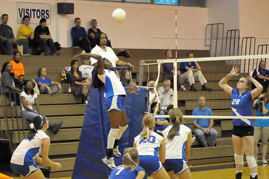 Breanna White goes up hit for a spike as her teammates get into position. (Photo by Kevin Nagle)