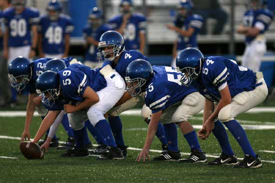Bryant Blue quarterback Brandon Warner (4) prepares to start a play behind linemen Brittan Crouch (54), Nic Jenkins (55), Zach McConnell (59). (Photo by Kevin Nagle)