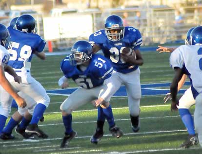 Bryant Blue's Kyle Lovelace (51) and Zach McConnell (59) try to clear some space to run for Brendan Young (33). (Photo by Kevin Nagle)