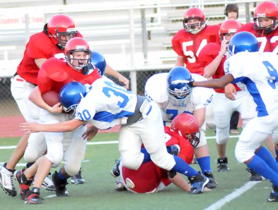 Bryant White's Austin Trusty (30) makes a tackle as Steven Murdock (9) arrives to help. (Photo by Kevin Nagle)