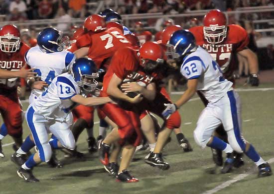 Bryant's Kelsey Hamilton (13) and Jason Browning (32) close in on a tackle as Amador Gaspar (64) tries to get free to help. (Photo by Kevin Nagle)