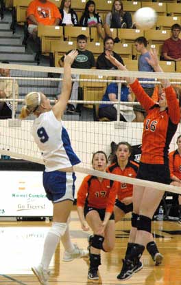 Maggie Hart (9) sends a hit over the block attempt of a pair of Heritage players. (Photo by Mark Hart)