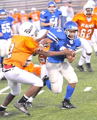 Brushawn Hunter (34) heads up the field after blocks by Brittan Crouch (54) and Nic Jenkins (55). (Photo by Kevin Nagle)