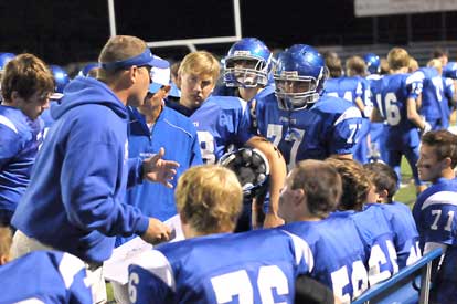 Offensive coaches Elliott Jacobs and Kirk Bock huddle up with their players on the sideline. (Photo by Kevin Nagle)