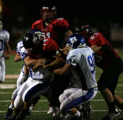 Josh Hampton (98) and Austin Dunahoo (94) wrap up Russellville quarterback Lane Reves. (Photo by Rick Nation)