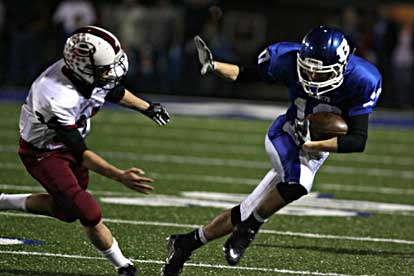 Caleb Garrett tries to evade a Springdale tackler Cory Shipman after catching a pass. (Photo by Rick Nation)