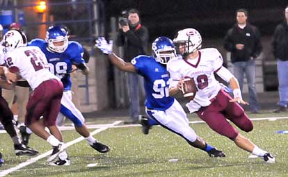 James Kidd (92) and Josh Hampton (98) pressure Springdale quarterback Joseph Calcagni (Photo by Kevin Nagle)