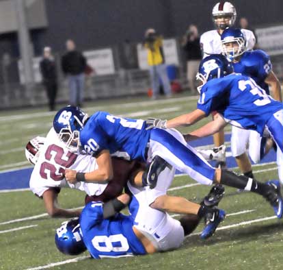 Hunter Mayall (18) and Tanner Tolbert (20) bring down K.D. Jones (22) as help arrives from Holden Chavis (30). (Photo by Kevin Nagle)