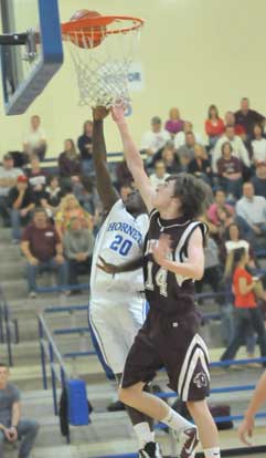 Greyson Giles goes up for a lay-in against Benton's Blake Bowlin. (Photo by Kevin Nagle)