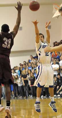 Bryant's Brantley Cozart launches a shot over Benton's Eddie Poland (31). (Photo by Kevin Nagle)