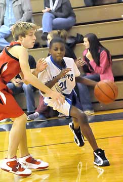 Kyron Smith (21) tries to drive the baseline. (Photo by Kevin Nagle)