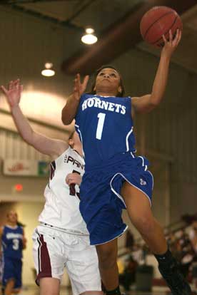 Kiara Moore goes in for a layup in front of Benton's Brooke Million. (Photo by Rick Nation))