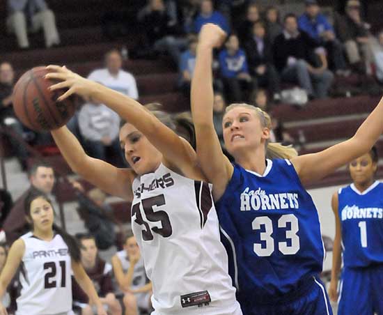 Benton's Madi Brooks claims a rebound as Bryant's Abbi Stearns (33) takes a swipe at it. (Photo by Kevin Nagle)